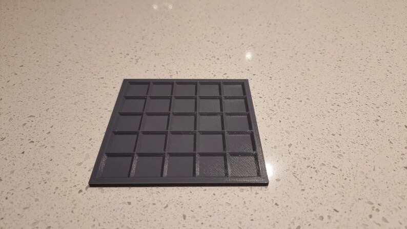 May include: A black plastic grid with 36 square compartments.