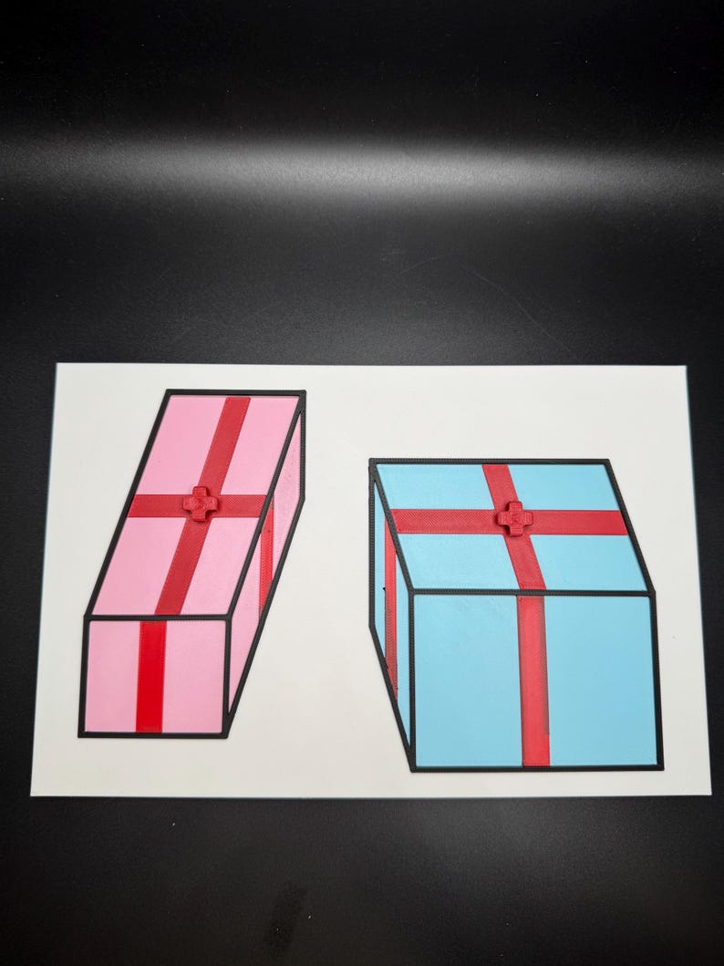 May include: Two colorful gift boxes, one pink and one blue, are depicted on a white background. Each box is adorned with a red ribbon and a decorative accent. The boxes have black outlines.