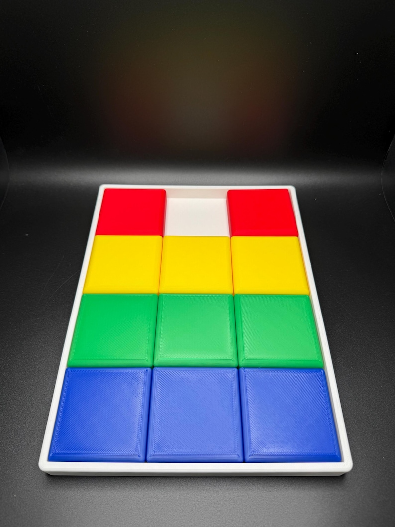 May include: A white tray with nine square blocks in four colors: red, yellow, green, and blue. The blocks are arranged in a pyramid shape, with the red blocks at the top, followed by yellow, green, and blue.