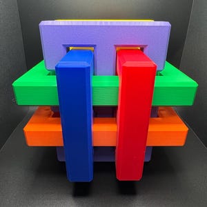 May include: A colorful wooden puzzle with interlocking pieces. The puzzle is made of five pieces, each a different color: purple, green, orange, blue, and red.