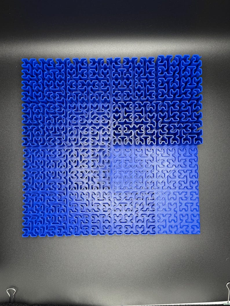 May include: A blue interlocking puzzle mat made of plastic. The mat is made up of small squares that fit together to create a larger surface.
