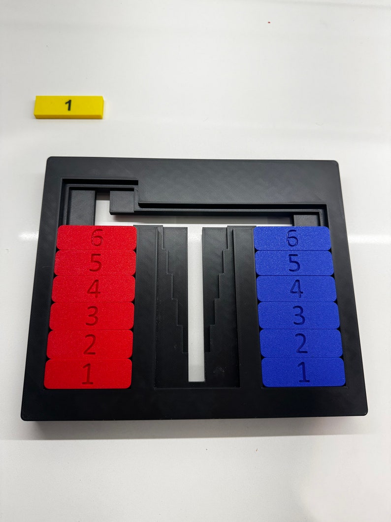 May include: A black puzzle game with two rows of numbered tiles. The tiles on the left are red and the tiles on the right are blue. The numbers 1 through 6 are visible on each side.