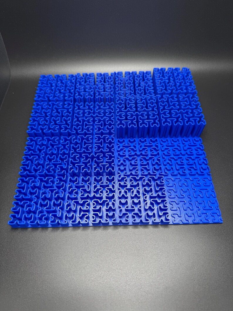May include: A blue plastic puzzle with interlocking pieces. The puzzle is made up of many small squares, each with a unique shape. The puzzle is arranged in a grid pattern.