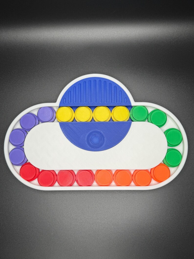 May include: A white cloud-shaped pop-it fidget toy with a blue center and rainbow colored circles around the edge. The toy has a variety of colors including purple, yellow, green, red, and orange.