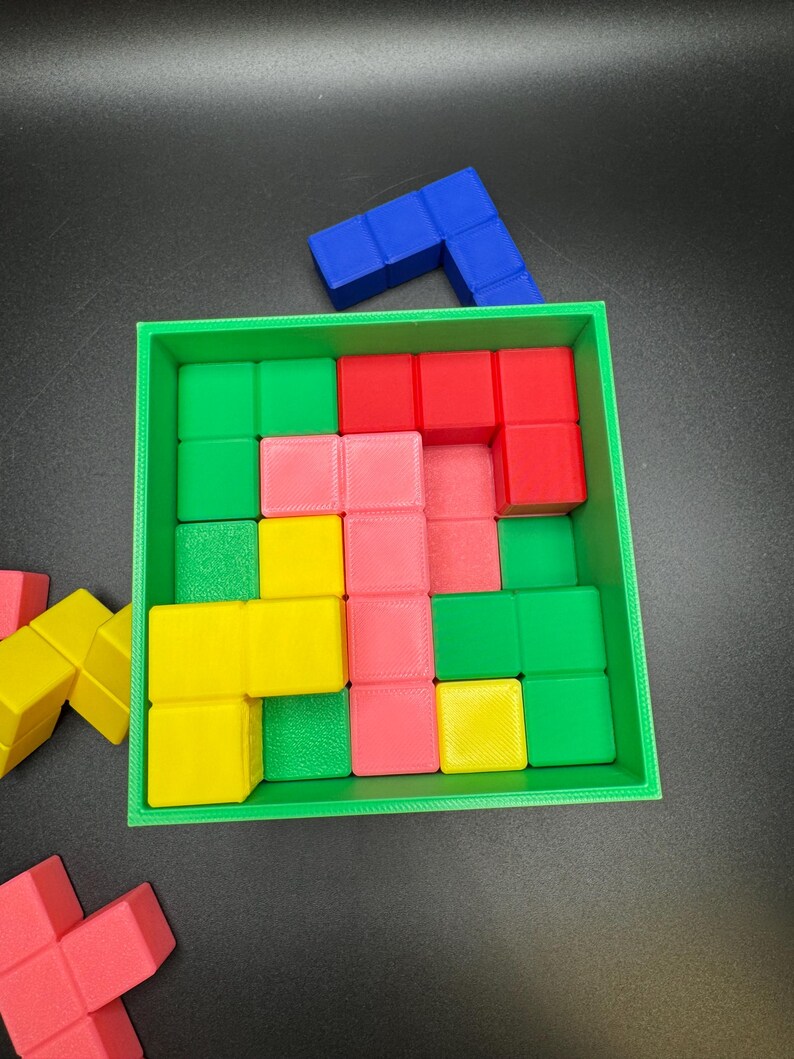 May include: A colorful puzzle game with a green square frame. The game includes red, pink, yellow, green, and blue blocks. Some blocks are inside the frame, and others are scattered around the frame.