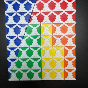 May include: A close-up of a colorful geometric pattern made of tiles. The tiles are arranged in a grid pattern and are colored blue, red, green, and yellow. Each tile features a white bunny rabbit design.