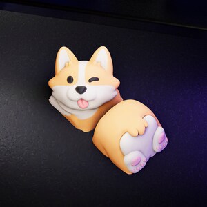 Op de afbeelding: Speelse corgi-figuur in oranje, wit en beige. De corgi knipoogt en steekt zijn tong uit. De figuur bestaat uit twee delen, waarbij de achterkant van de corgi zichtbaar is.