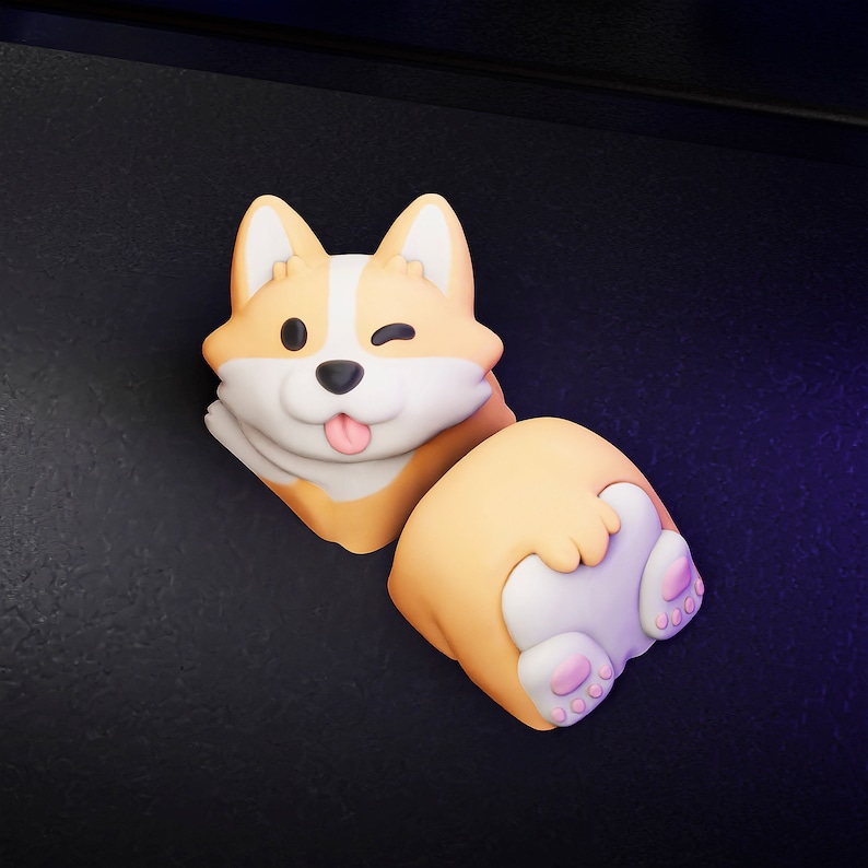 Op de afbeelding: Speelse corgi-figuur in oranje, wit en beige. De corgi knipoogt en steekt zijn tong uit. De figuur bestaat uit twee delen, waarbij de achterkant van de corgi zichtbaar is.