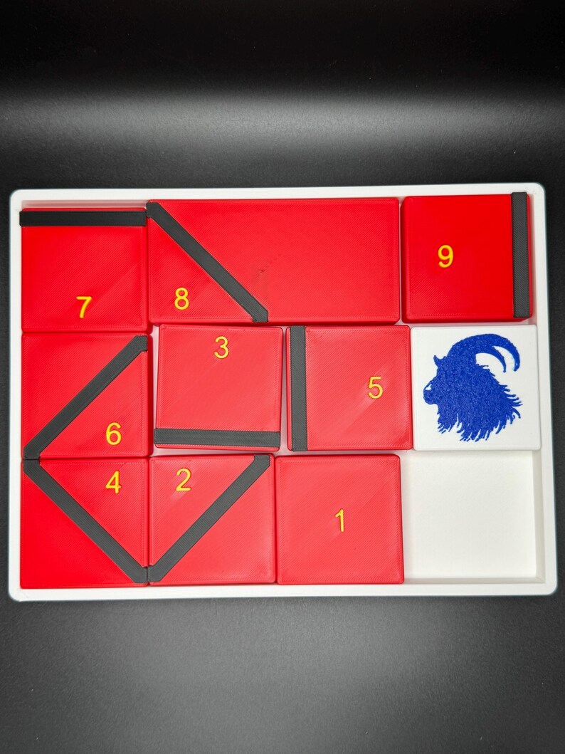 May include: A red and black puzzle with nine numbered squares and a white square with a blue goat illustration. The numbers 1 through 9 are visible on the red squares.