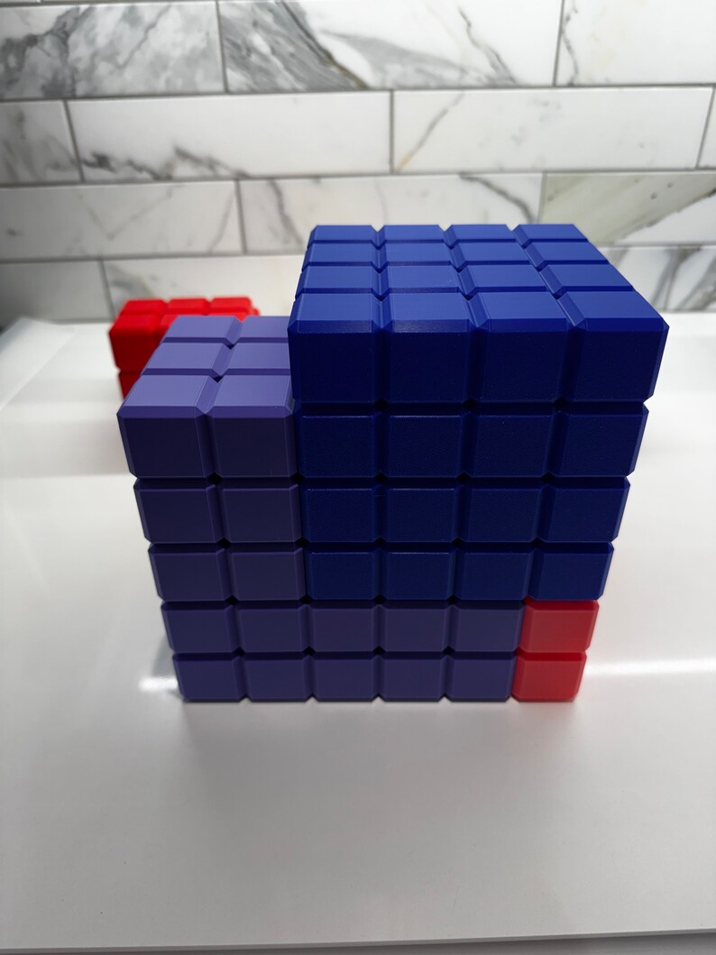 May include: A blue and purple building block structure with a red block on the side. The structure is made of small square blocks.