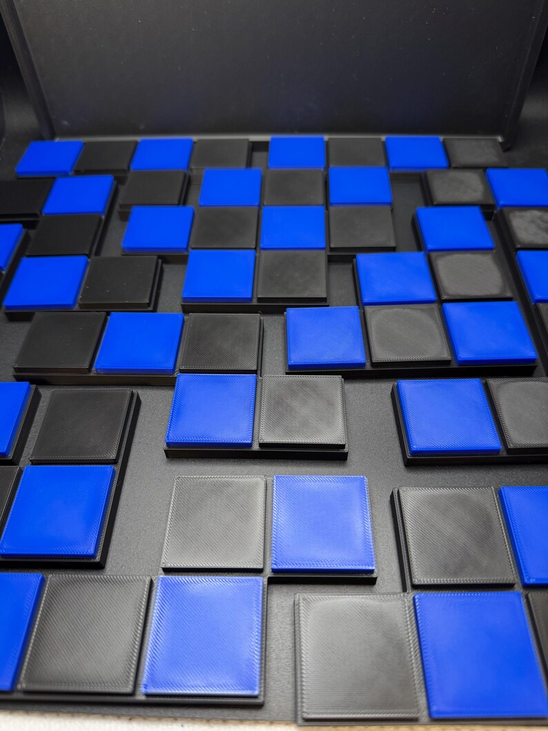 May include: A checkerboard pattern of alternating black and blue squares. The squares are raised and arranged in a grid, creating a 3D effect. The color scheme is a striking contrast of black and bright blue.