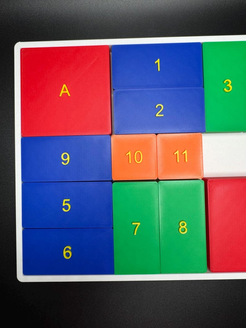 May include: A colorful puzzle with numbered and lettered tiles. The tiles are arranged in a grid pattern. The tiles are red, blue, green, orange, and white.