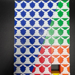 May include: A geometric pattern made of white plastic tiles with a bunny rabbit design. The tiles are arranged in a grid pattern and are colored blue, green, red, orange, and yellow.