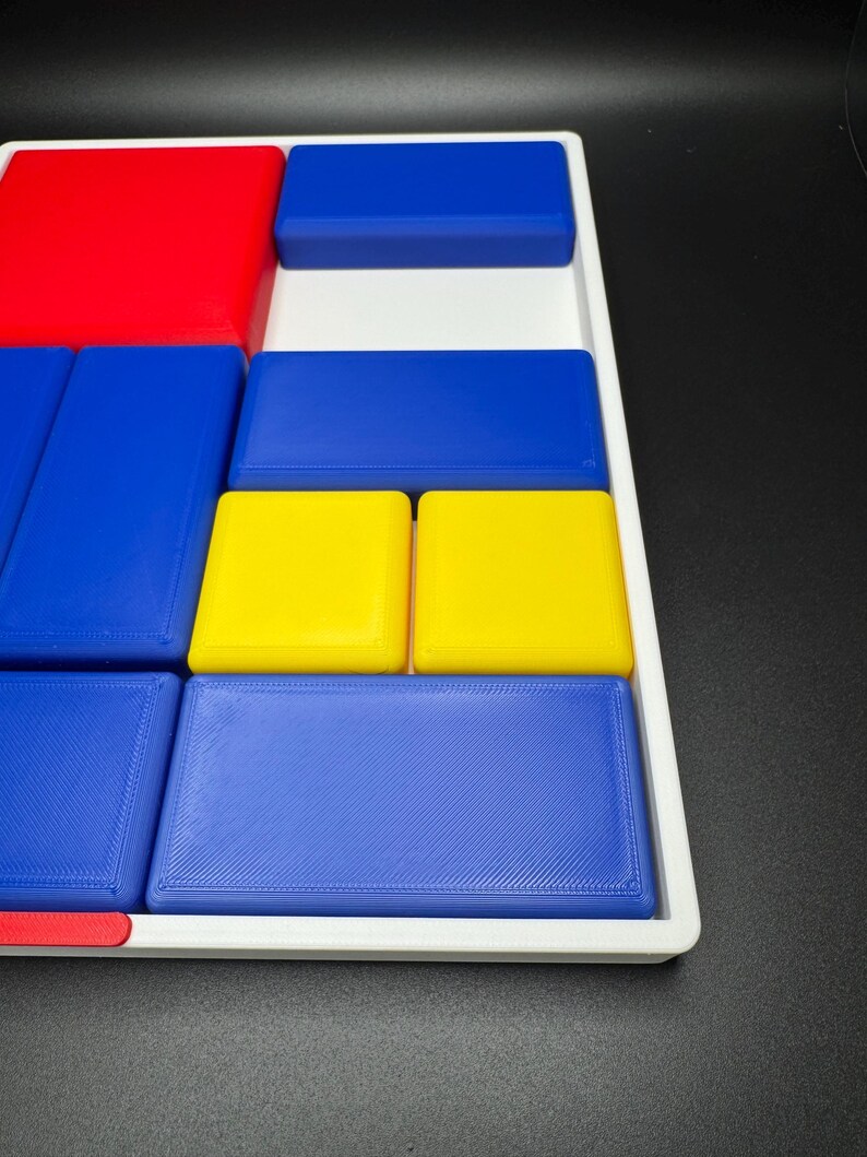 Op de afbeelding: Een wit dienblad met een verscheidenheid aan gekleurde blokken. De blokken zijn rood, blauw en geel. De blokken zijn in een patroon gerangschikt.