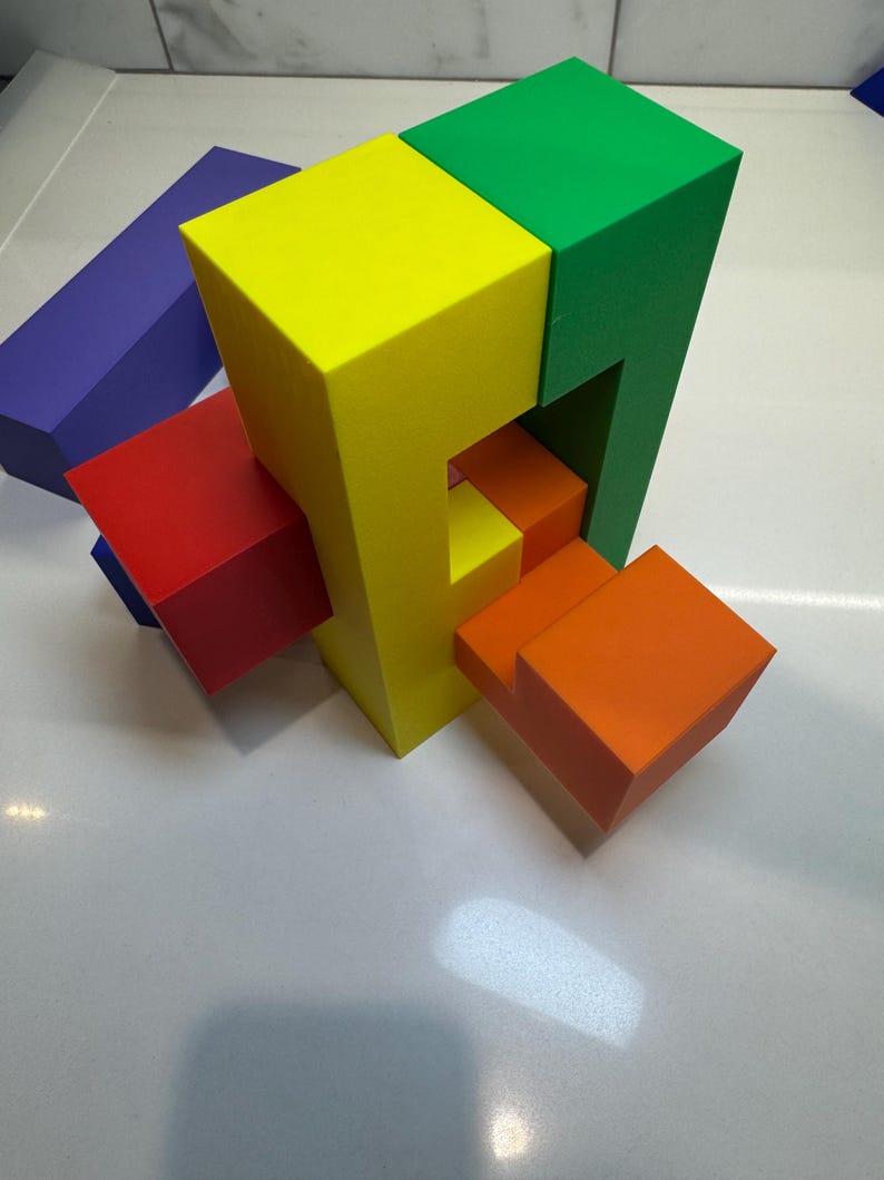 May include: A colorful wooden puzzle with five blocks in different colors: yellow, green, red, orange, and purple. The blocks are arranged in a complex pattern, creating a challenging puzzle.