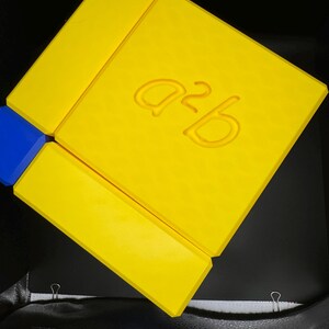 May include: A yellow cardboard box with the text "a2b" printed on the top.