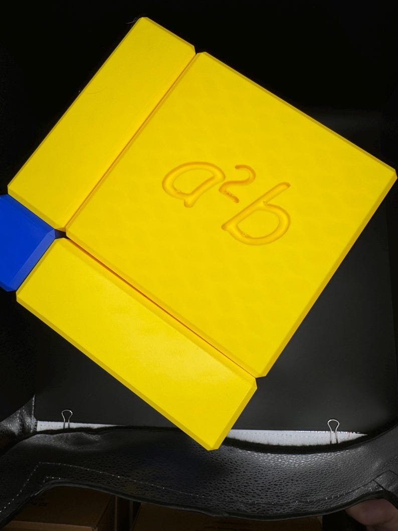 May include: A yellow cardboard box with the text "a2b" printed on the top.