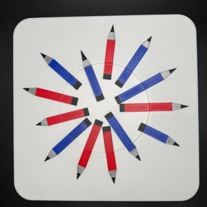 Op de afbeelding: Een wit rond oppervlak met 12 potloden in een cirkel gerangschikt. De potloden wisselen elkaar af in rood en blauw.
