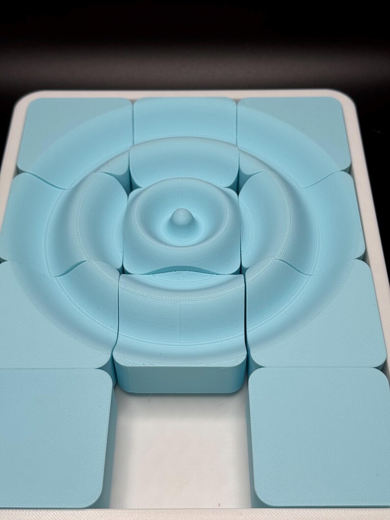 May include: A light blue puzzle with 12 pieces that fit together to form a circular pattern. The puzzle is made of plastic and has a smooth, matte finish.