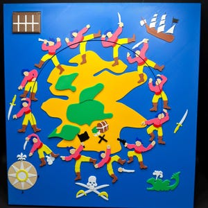 May include: A colorful, 3D pirate-themed artwork on a blue background. The piece features a yellow island, red-clad pirates, a brown ship, a compass, and a skull and crossbones. The artwork is a playful depiction of a pirate adventure.