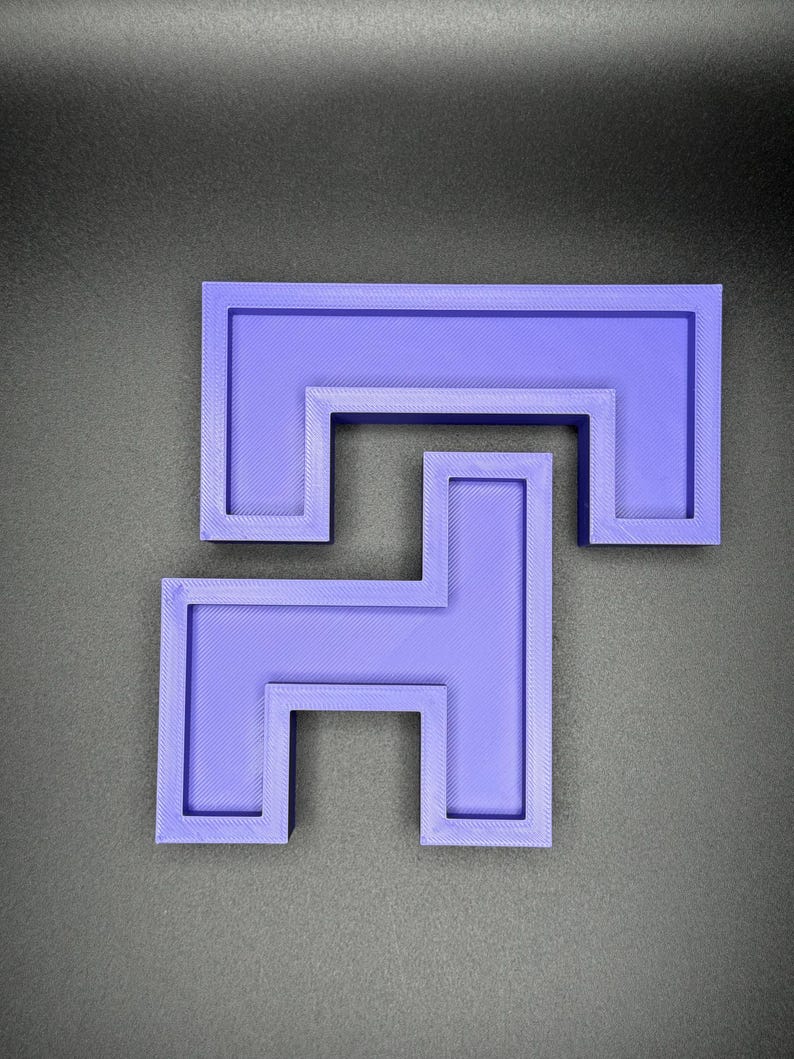 Puede incluir: Un rompecabezas de pl&aacute;stico morado impreso en 3D con un dise&ntilde;o de enclavamiento &uacute;nico. El rompecabezas est&aacute; formado por dos piezas que encajan para formar una forma m&aacute;s grande.