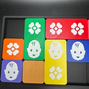 May include: Nine colorful square tiles with different images. The images include a flower, a baby face, and the letters "NY". The tiles are arranged in a grid pattern.