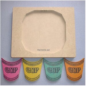 May include: A wooden frame with a circular cutout, accompanied by four colorful, cup-shaped cutouts. The cutouts are pink, yellow, teal, and orange, each with the word "CUP" printed on them. The website address "http://witful.net" is printed on the frame.