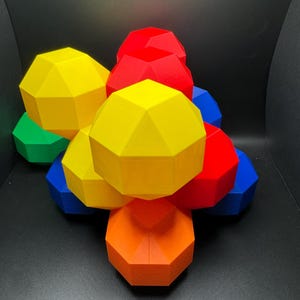May include: A group of colorful geometric shapes, stacked on top of each other. The shapes are red, yellow, orange, green, and blue.