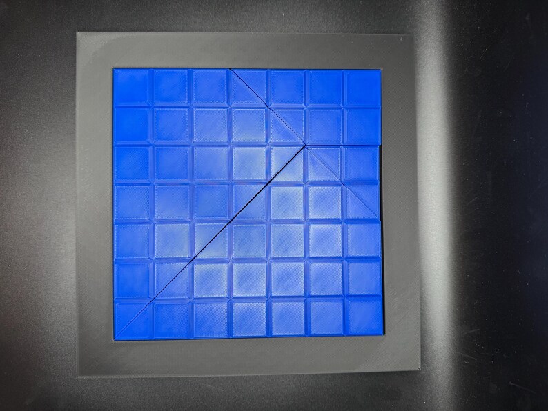 K&ouml;nnte beinhalten: Eine blaue quadratische Fliesenmatte mit einem Gittermuster. Die Matte ist durch eine diagonale Linie in zwei Dreiecke geteilt.