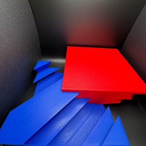 May include: A red and blue geometric shape made of cardboard. The red shape is a square and the blue shape is a series of triangles.