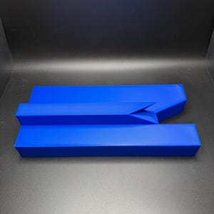 May include: A blue, three-piece, geometric puzzle made of plastic. The puzzle pieces fit together to form a shape.