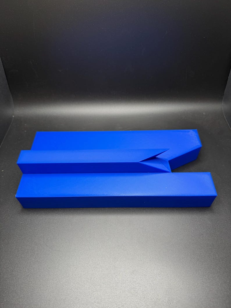 May include: A blue, three-piece, geometric puzzle made of plastic. The puzzle pieces fit together to form a shape.