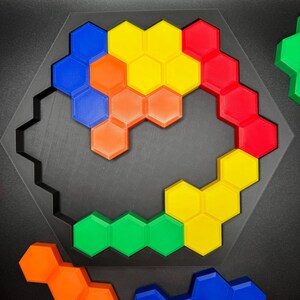 May include: A hexagonal puzzle with pieces in blue, red, yellow, green, and orange. The pieces are arranged in a spiral pattern.