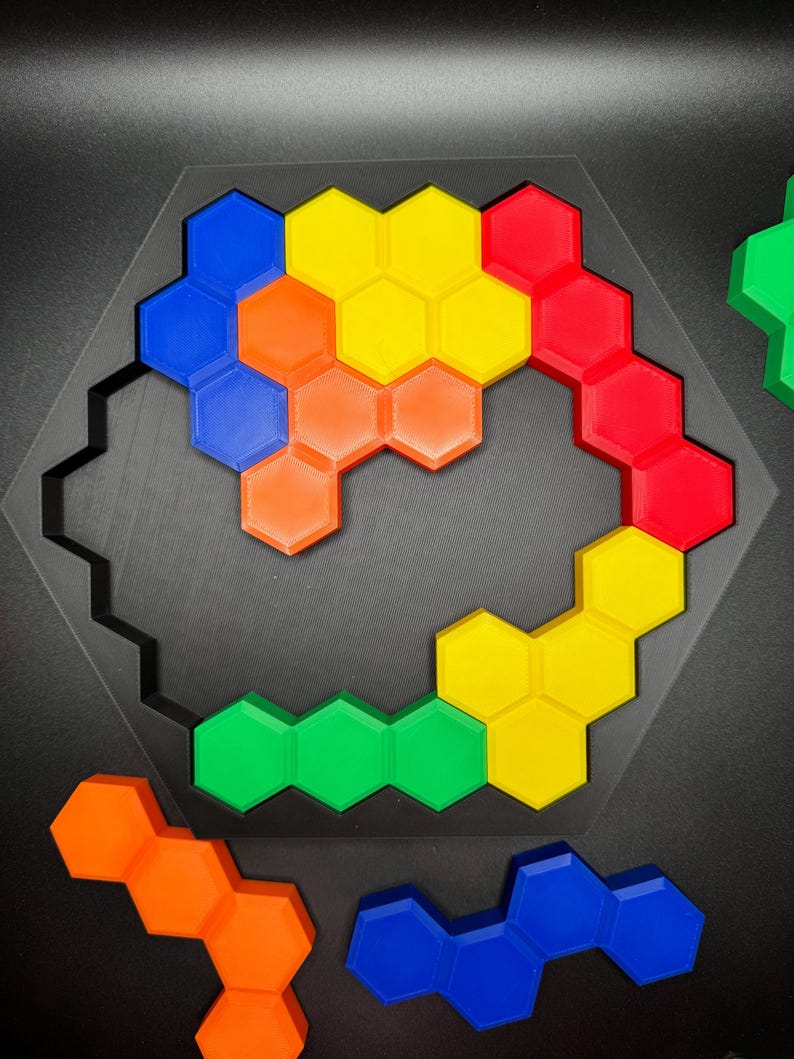 May include: A hexagonal puzzle with pieces in blue, red, yellow, green, and orange. The pieces are arranged in a spiral pattern.