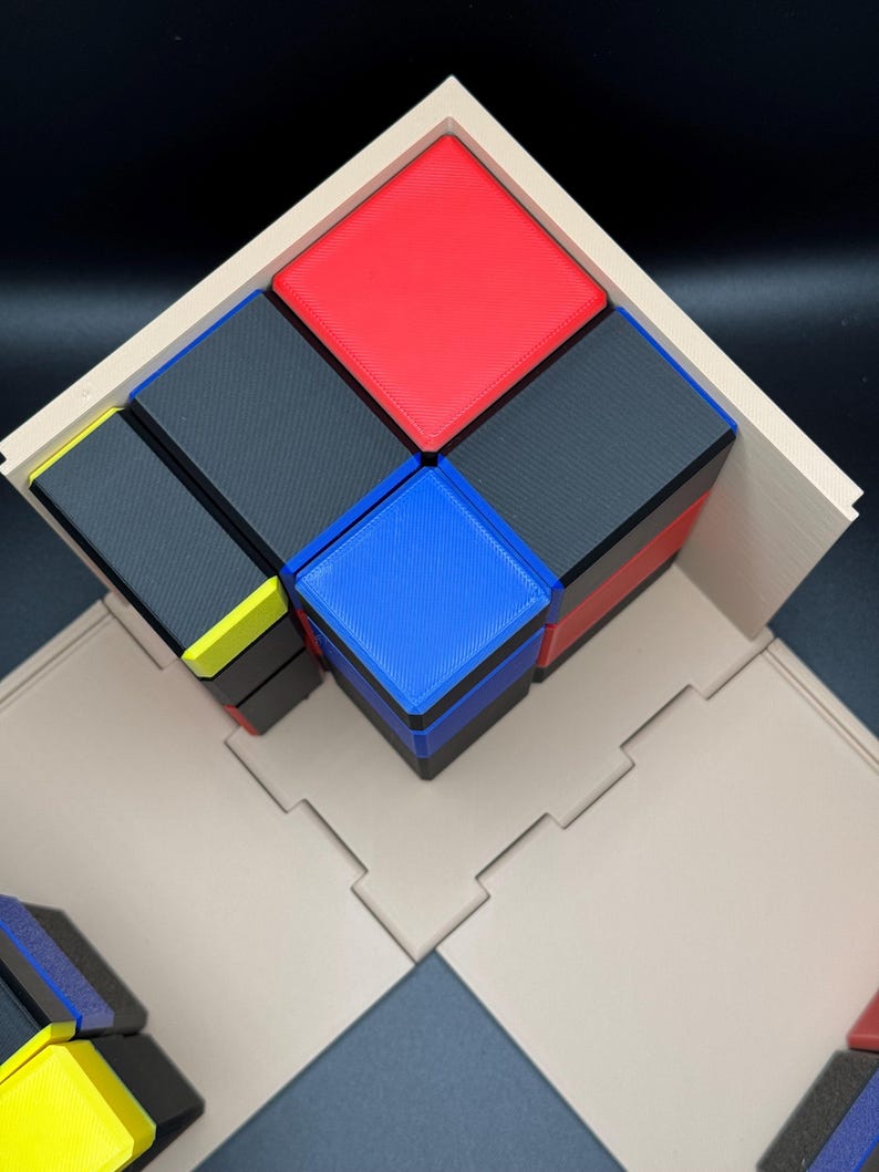 May include: A wooden frame holds a stack of colourful blocks. The blocks are arranged in a pyramid shape, with a red block on top, followed by a black block, then a blue block, and finally a black block on the bottom. The blocks are all the same size and shape.