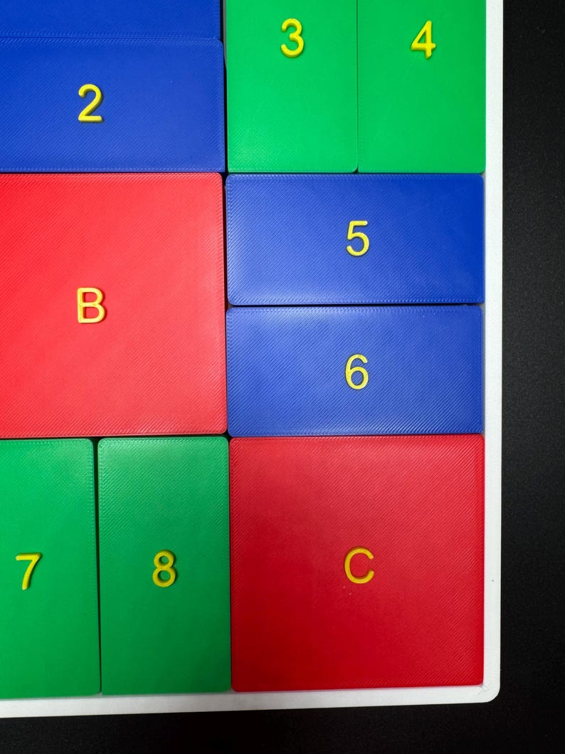 May include: A colorful puzzle with numbered and lettered tiles. The tiles are arranged in a grid pattern with red, blue, and green colors. The numbers 2, 3, 4, 5, 6, 7, and 8 are visible, along with the letters B and C.