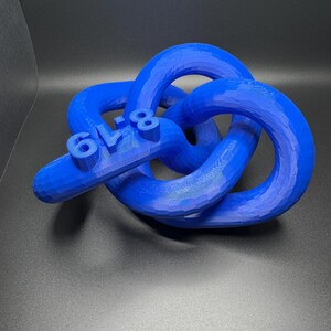 May include: A blue 3D printed knot sculpture with the number "618" printed on it.