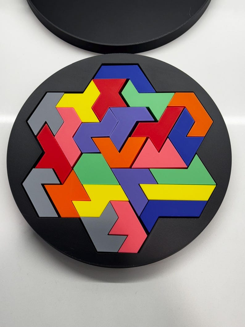 May include: A circular puzzle with a black background and a colorful geometric design. The puzzle pieces are made of different colors, including red, orange, yellow, green, blue, purple, and gray.