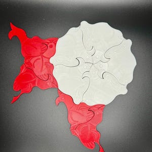 May include: A white and red interlocking puzzle with a floral design. The puzzle pieces are shaped like stylized flowers.