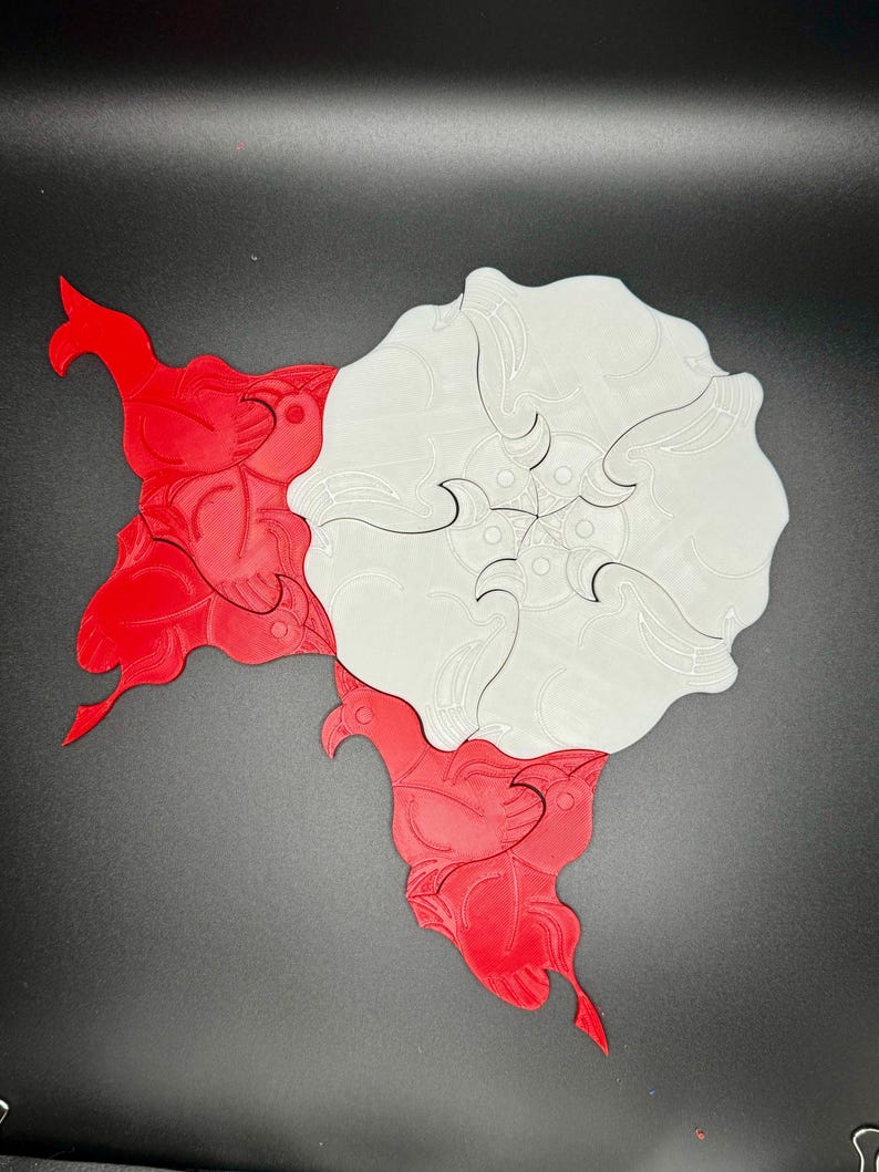 May include: A white and red interlocking puzzle with a floral design. The puzzle pieces are shaped like stylized flowers.