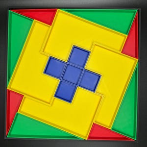 May include: A colorful geometric puzzle with a blue cross in the center. The puzzle is made of interlocking squares in red, green, and yellow.