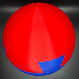 Puede incluir: Un juguete de rompecabezas esf&eacute;rico rojo y azul. La esfera est&aacute; hecha de dos mitades que encajan. La mitad superior es roja y la mitad inferior es azul.