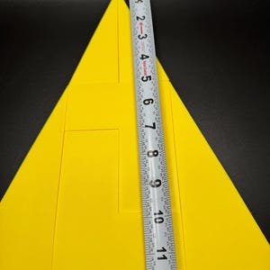 May include: A yellow triangle puzzle with a ruler measuring 12 inches. The puzzle is made up of smaller triangles and rectangles.
