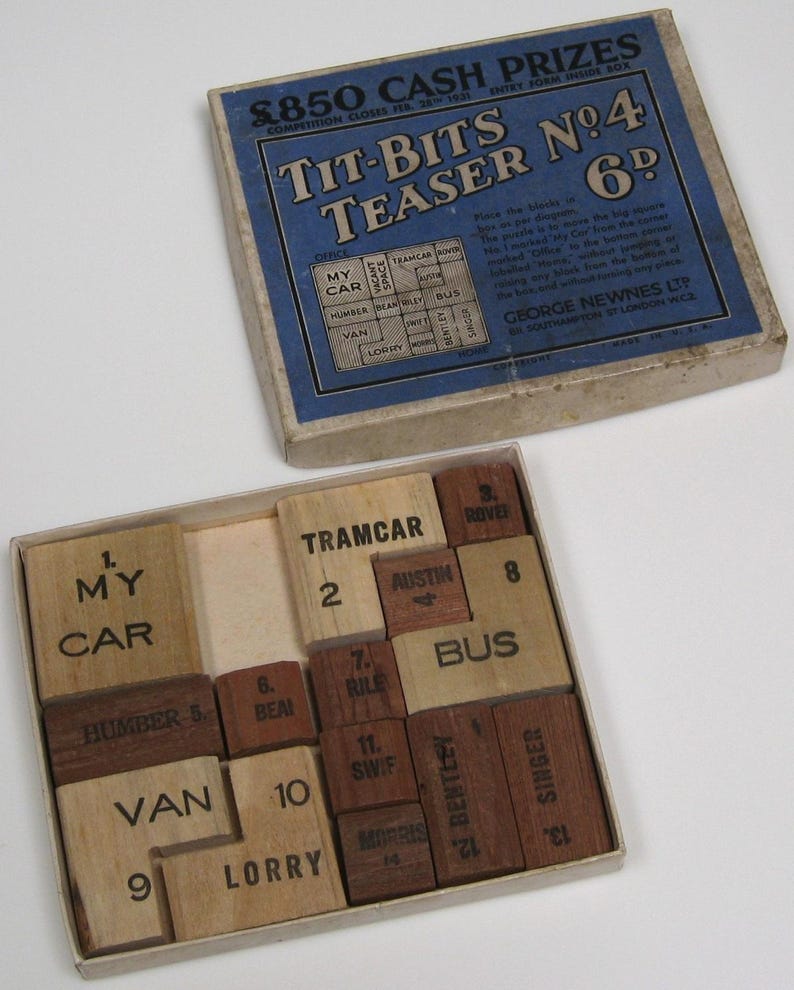 May include: A wooden puzzle game with 12 pieces, each with a number and a word printed on it. The words include "My Car", "Tramcar", "Rover", "Austin", "Bus", "Humber", "Bean", "Riley", "Swift", "Van", "Lorry", "Bentley", and "Singer". The puzzle is in a wooden box with a blue and white label that reads "Tit-Bits Teaser No. 4 6d".