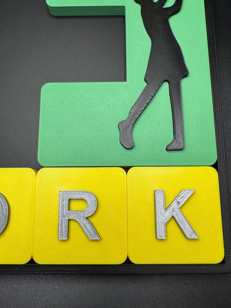 May include: A green and yellow 3D word art piece that spells out the word "WORK" with a silhouette of a person playing golf on top.
