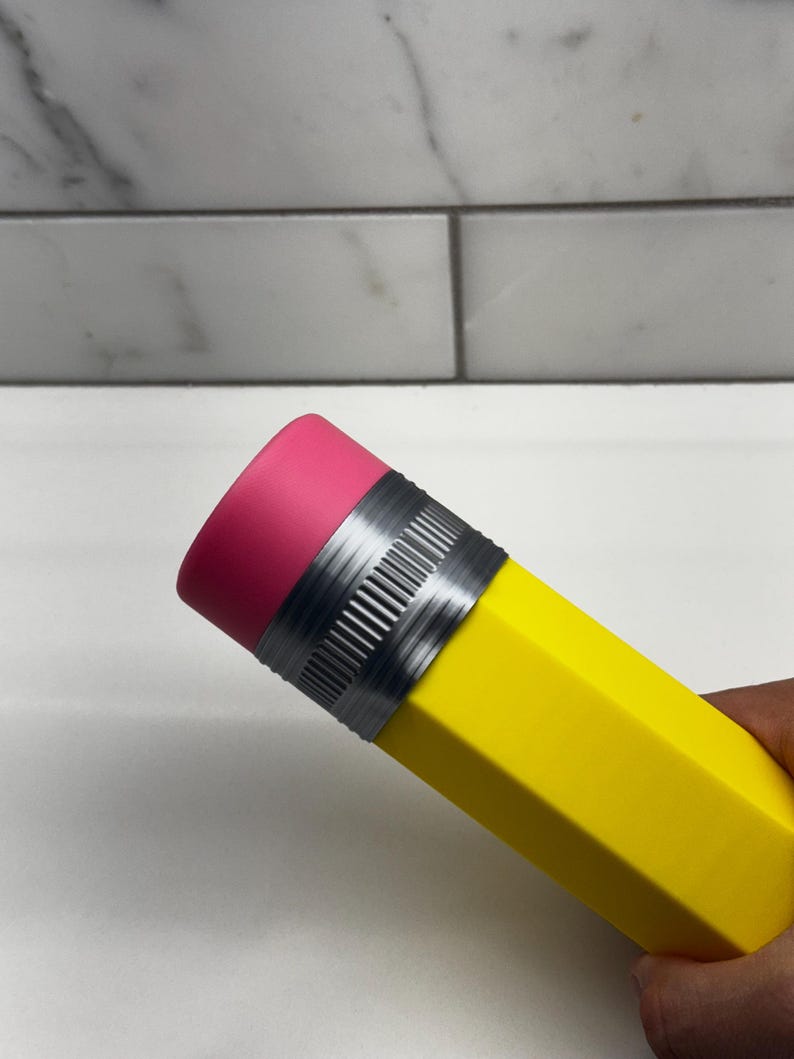 May include: A yellow pencil-shaped water bottle with a pink eraser top and a silver band.