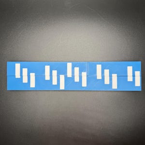 May include: A blue ruler with white markings. The ruler is divided into sections with white lines.