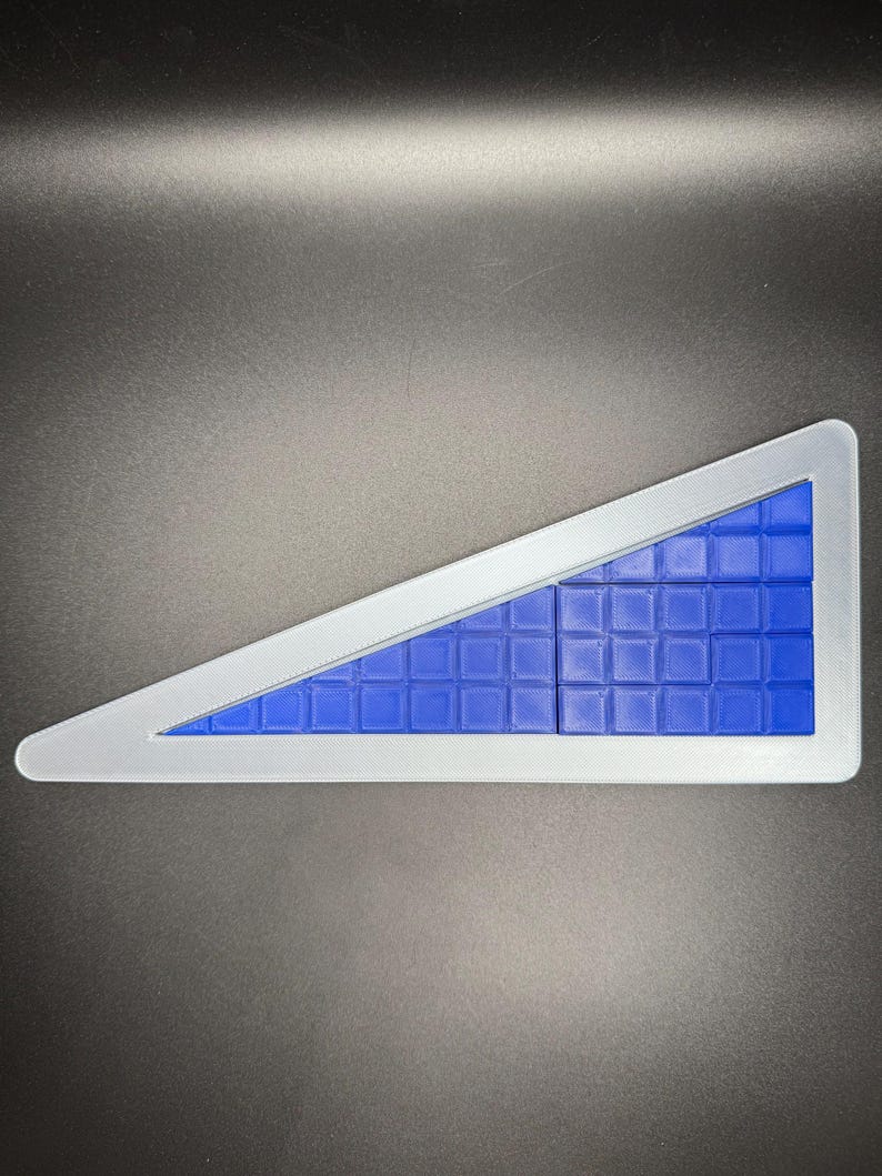 Puede incluir: Un rompecabezas triangular azul con un marco blanco. El rompecabezas est&aacute; formado por peque&ntilde;os cuadrados que encajan para formar un tri&aacute;ngulo m&aacute;s grande.