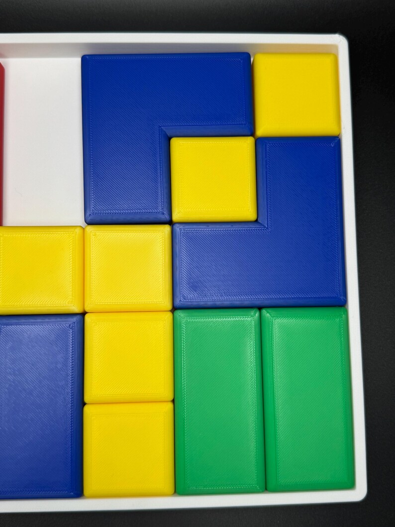 May include: A puzzle with blue, yellow, and green square tiles arranged in a grid pattern. The tiles are arranged in a way that creates a geometric design.