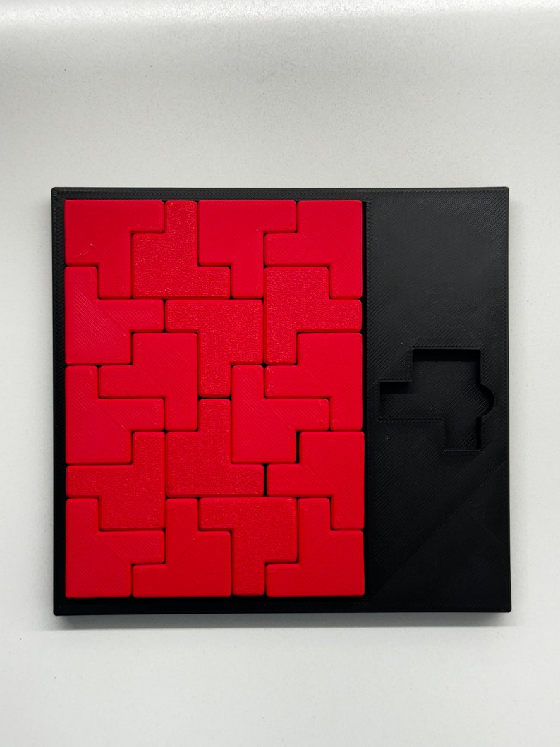 May include: A red and black puzzle game with a square grid of red tiles and a black frame. The game includes a black silhouette of a car on the right side of the frame.